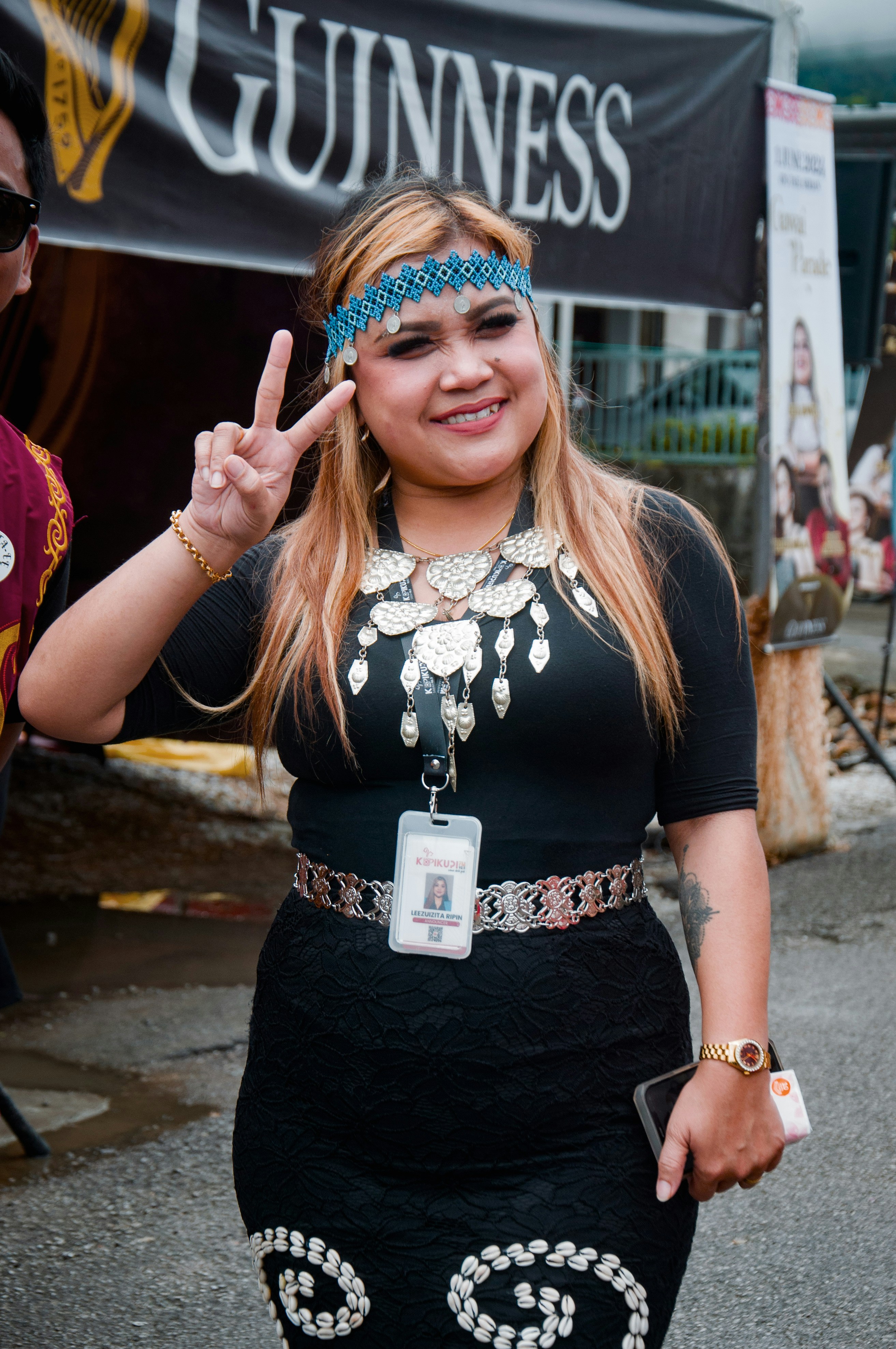 a woman in a black dress making a peace sign
