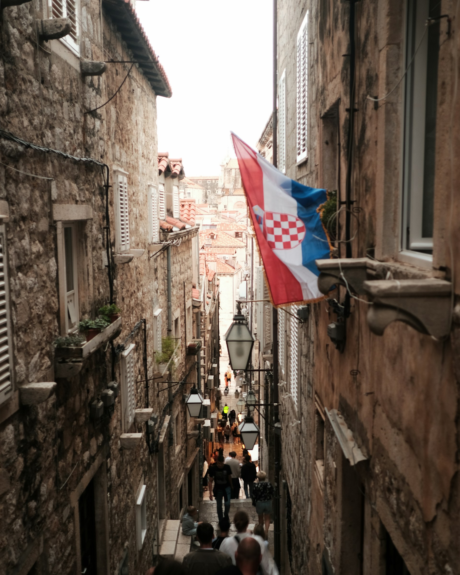 a narrow street with people walking down it