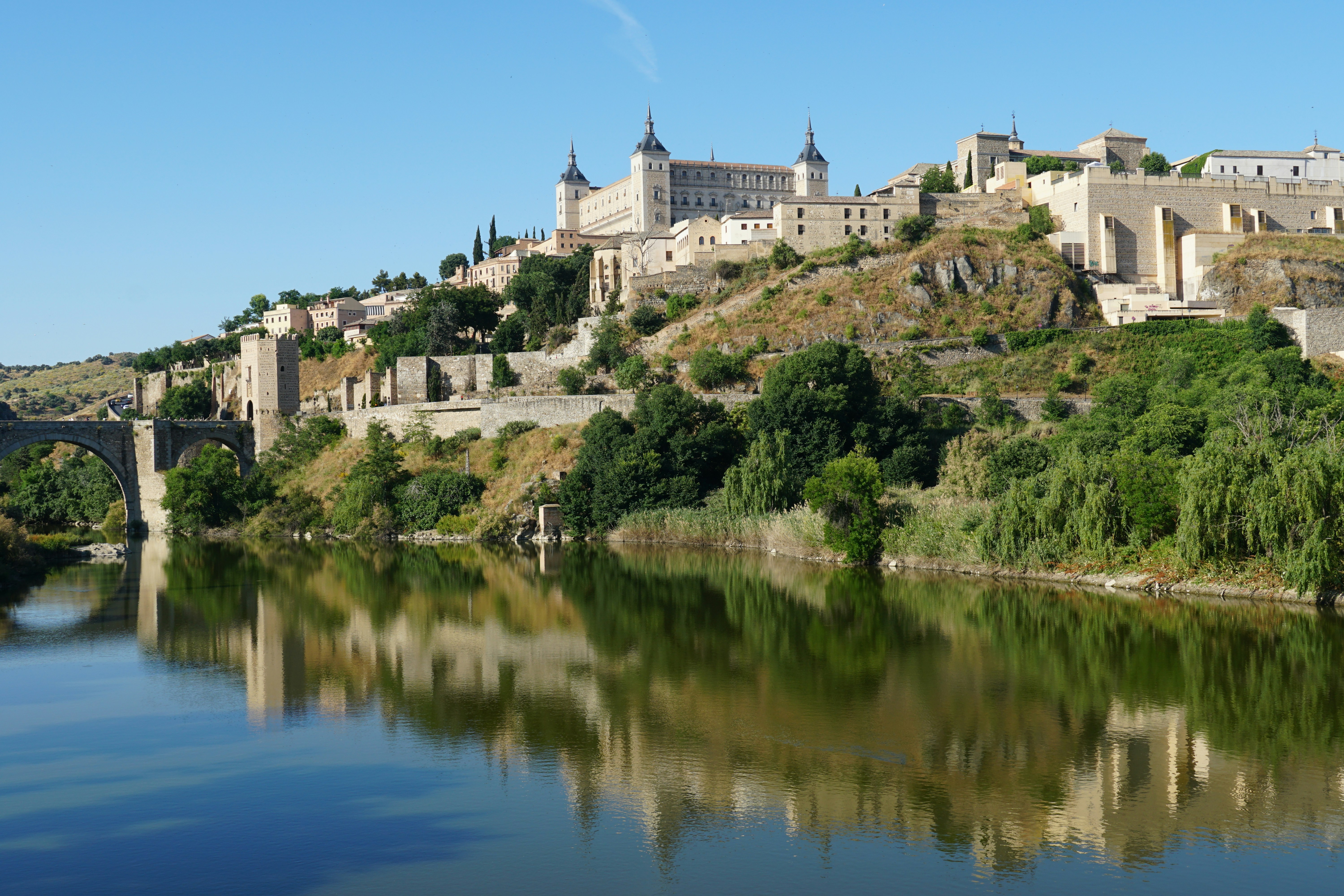 a castle on a hill above a river, 