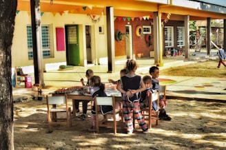 a group of children sitting around a table
