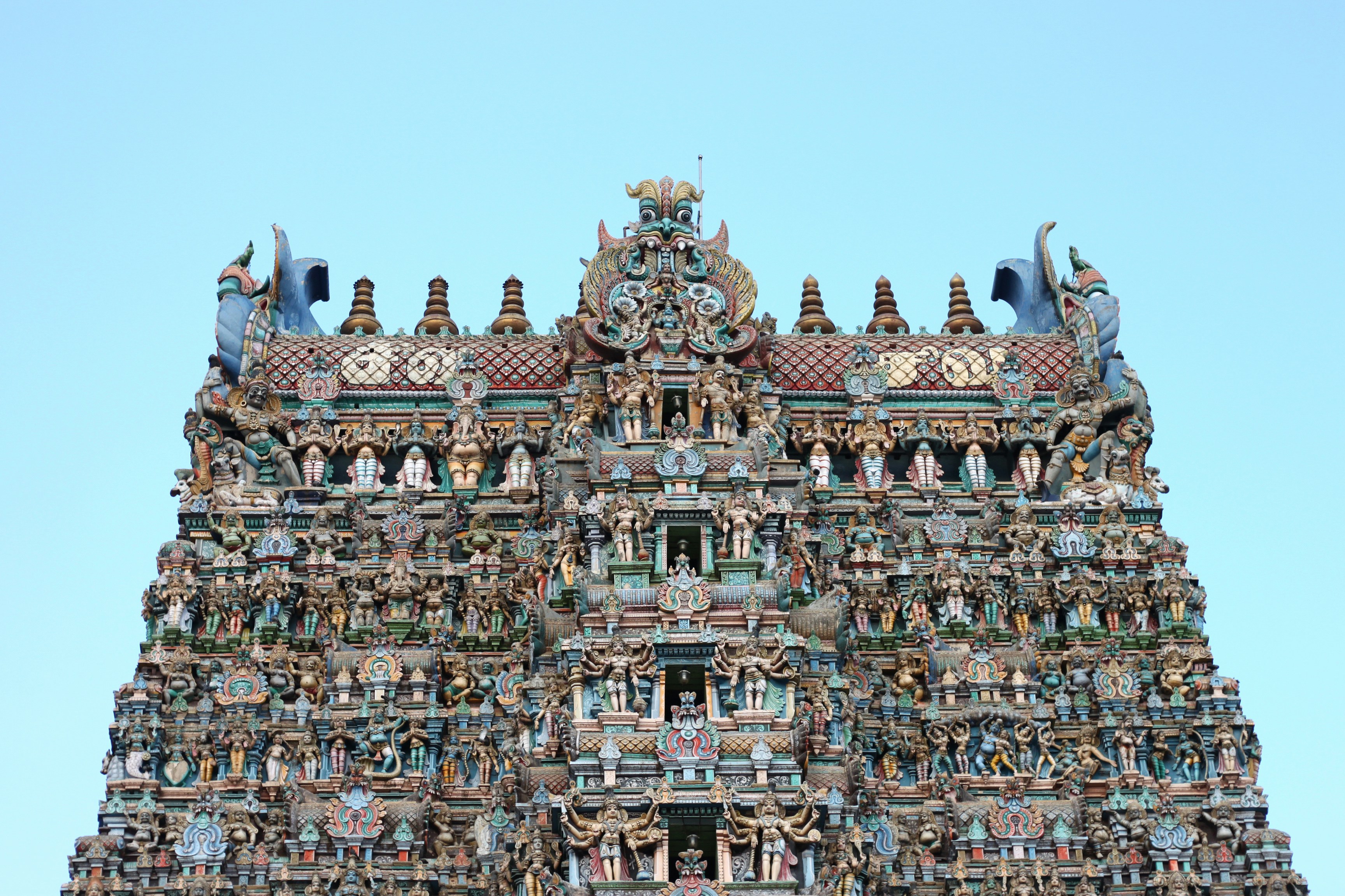 a very tall building with statues on it's sides