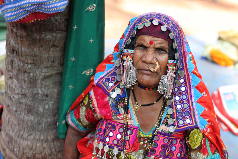 Indian sugar mama in a colorful dress by a tree