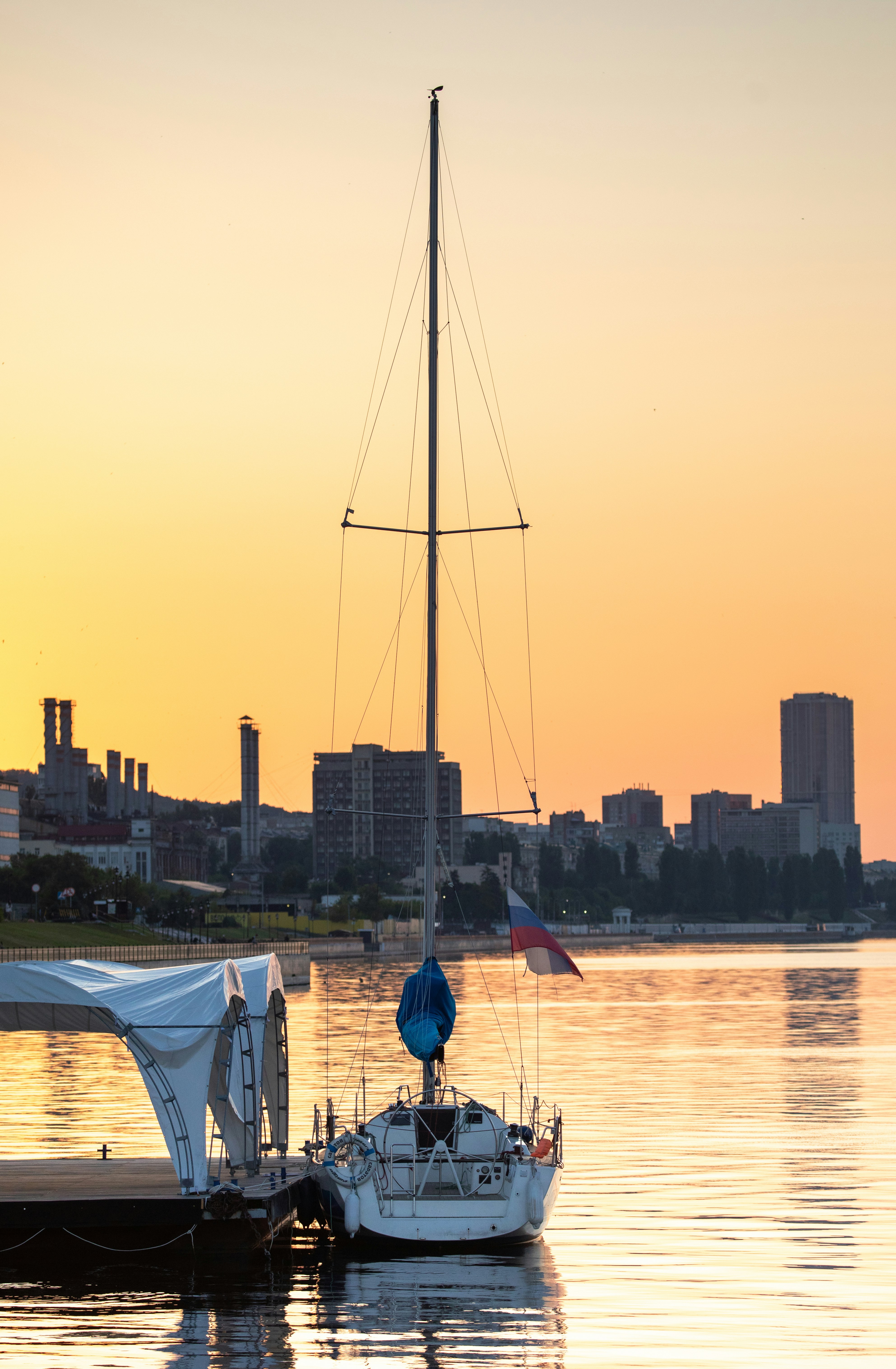 a sailboat is docked in the water at sunset
