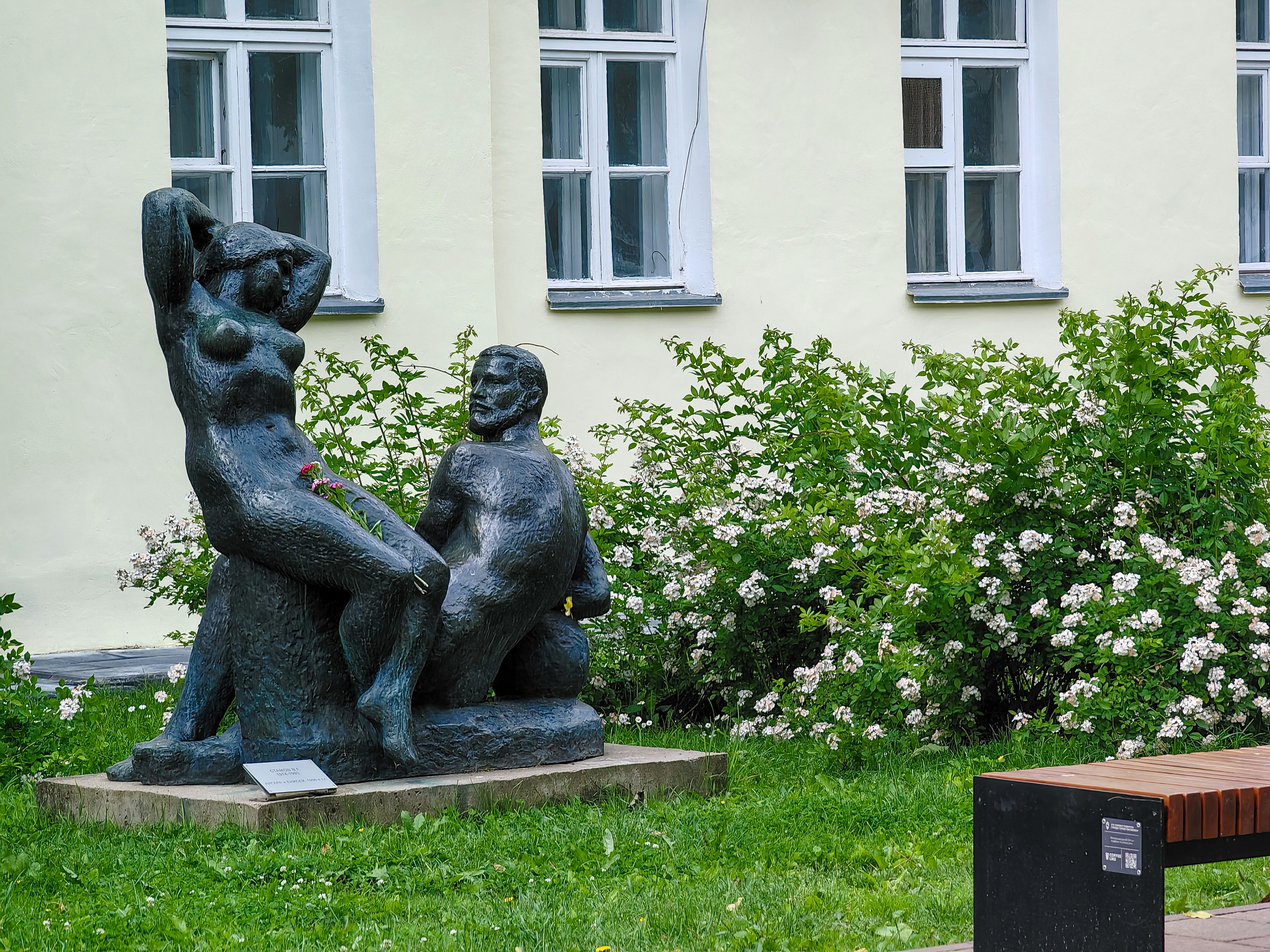 a couple of statues sitting on top of a lush green field
