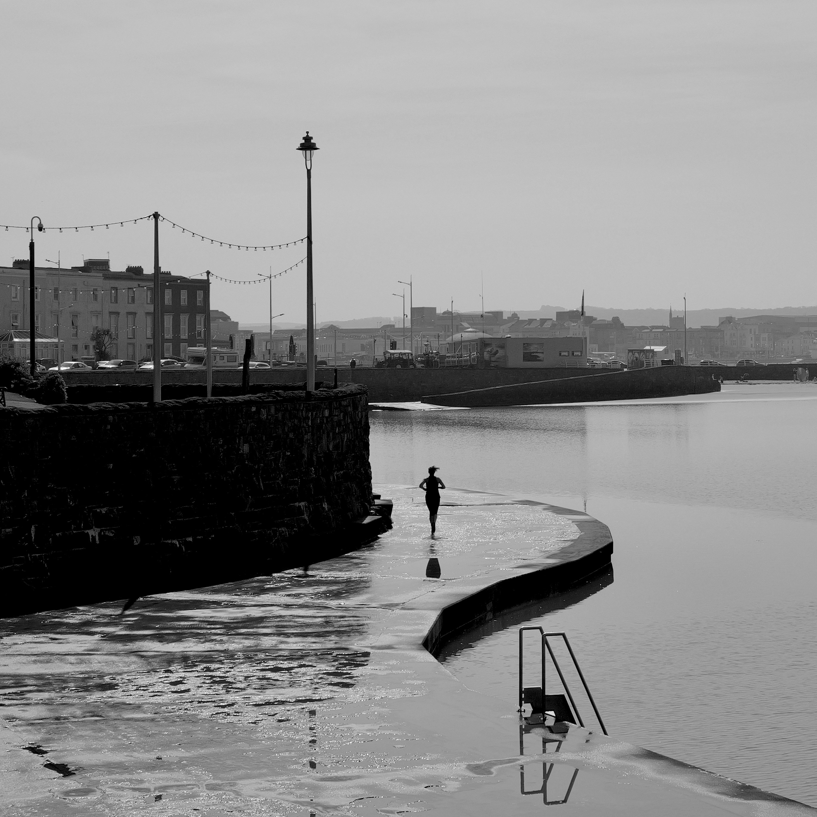 a black and white photo of a person standing in the water