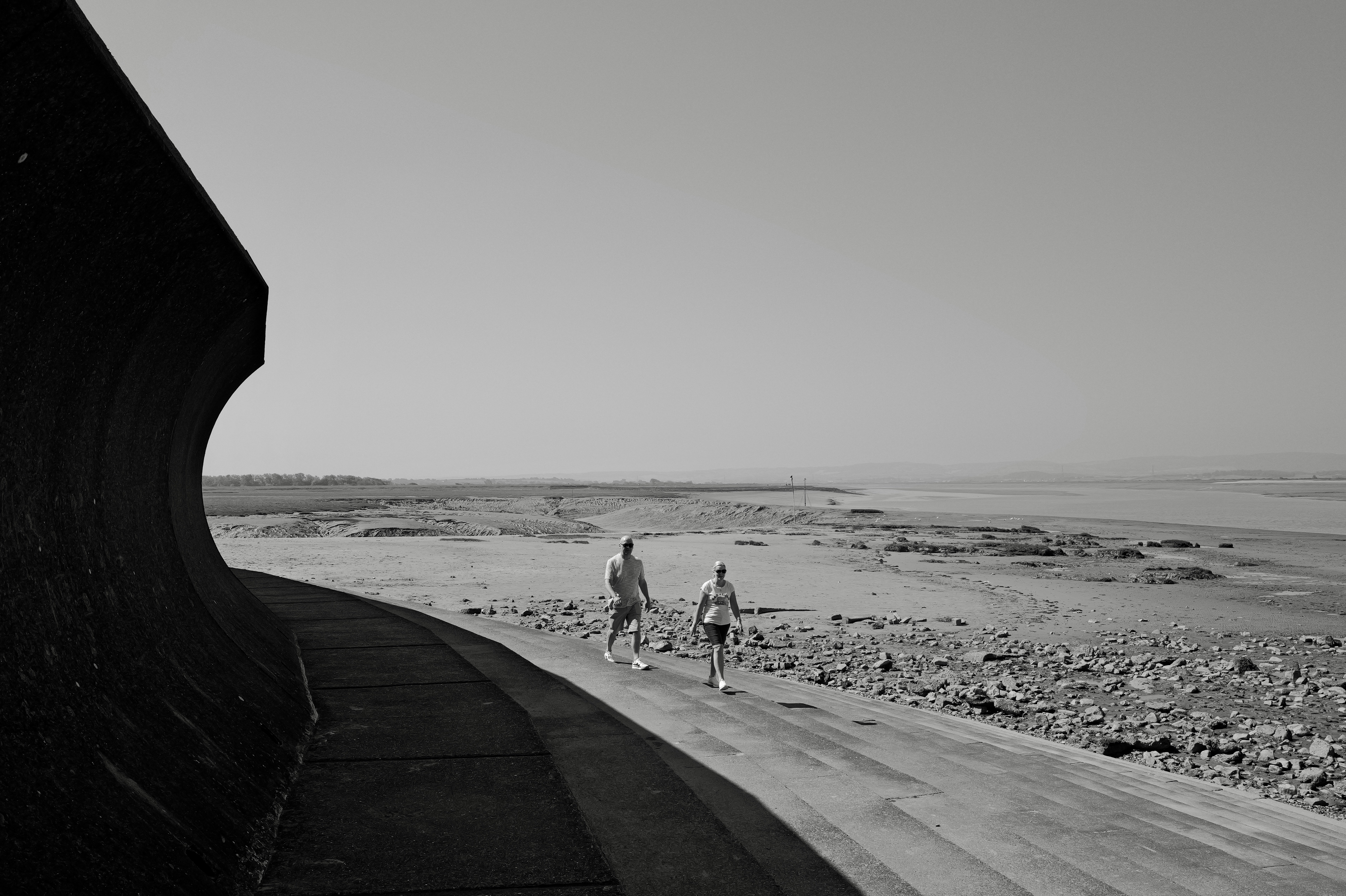a couple of people walking down a dirt road
