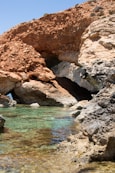 a body of water near a rocky cliff