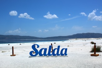 a sign that is on the sand near the water
