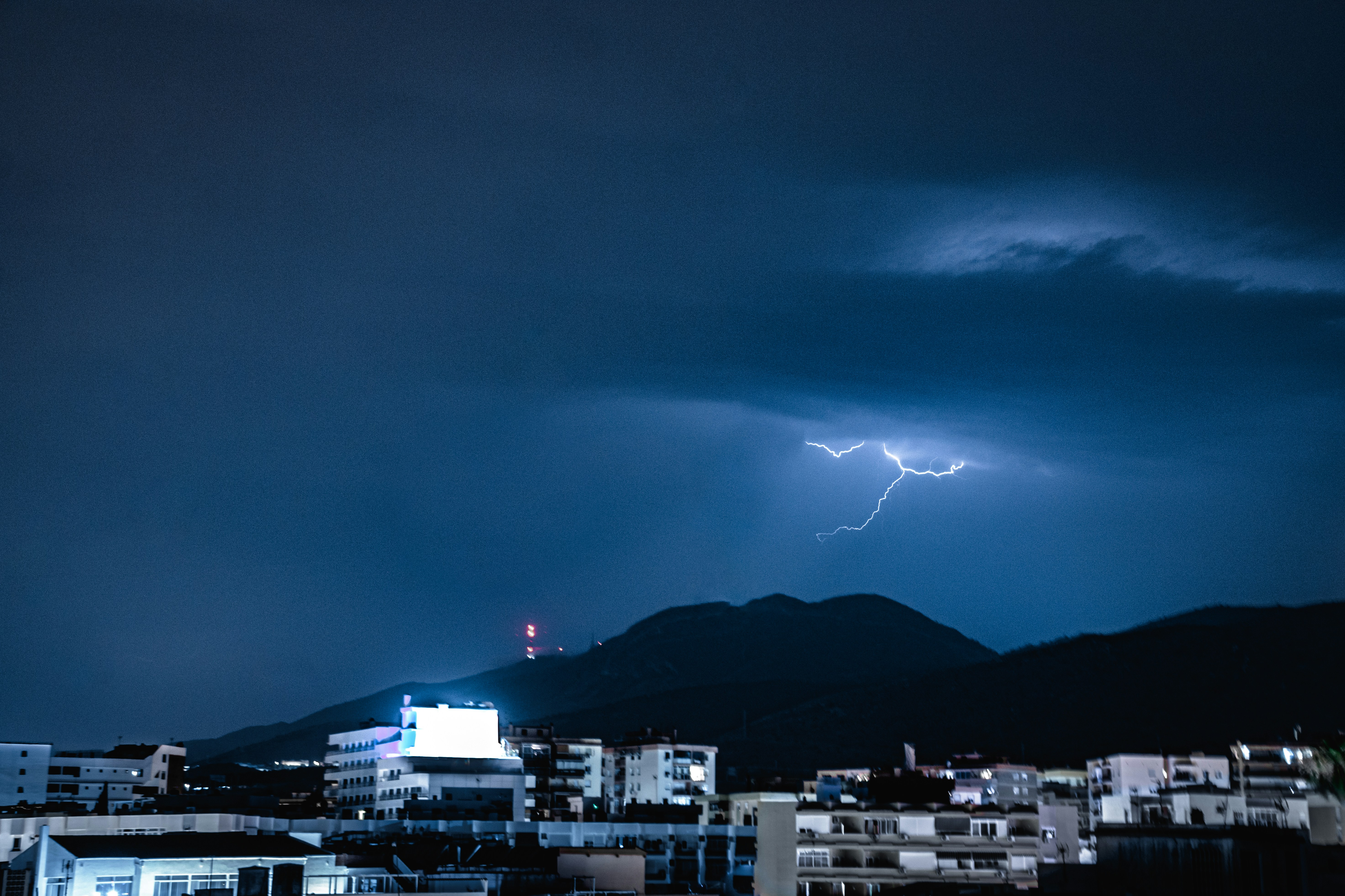 Un relámpago se ve sobre una ciudad por la noche
