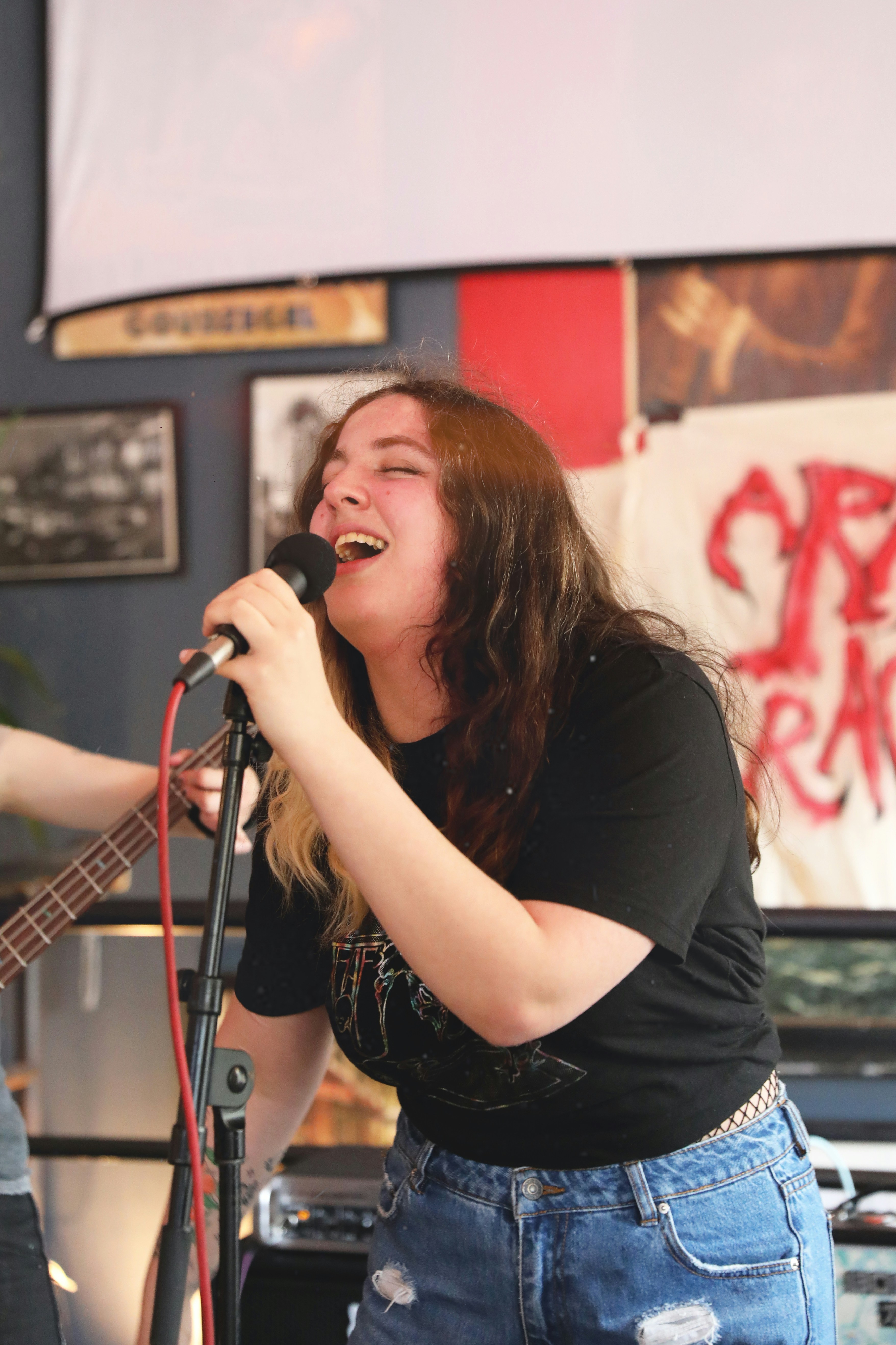 a woman singing into a microphone while holding a guitar