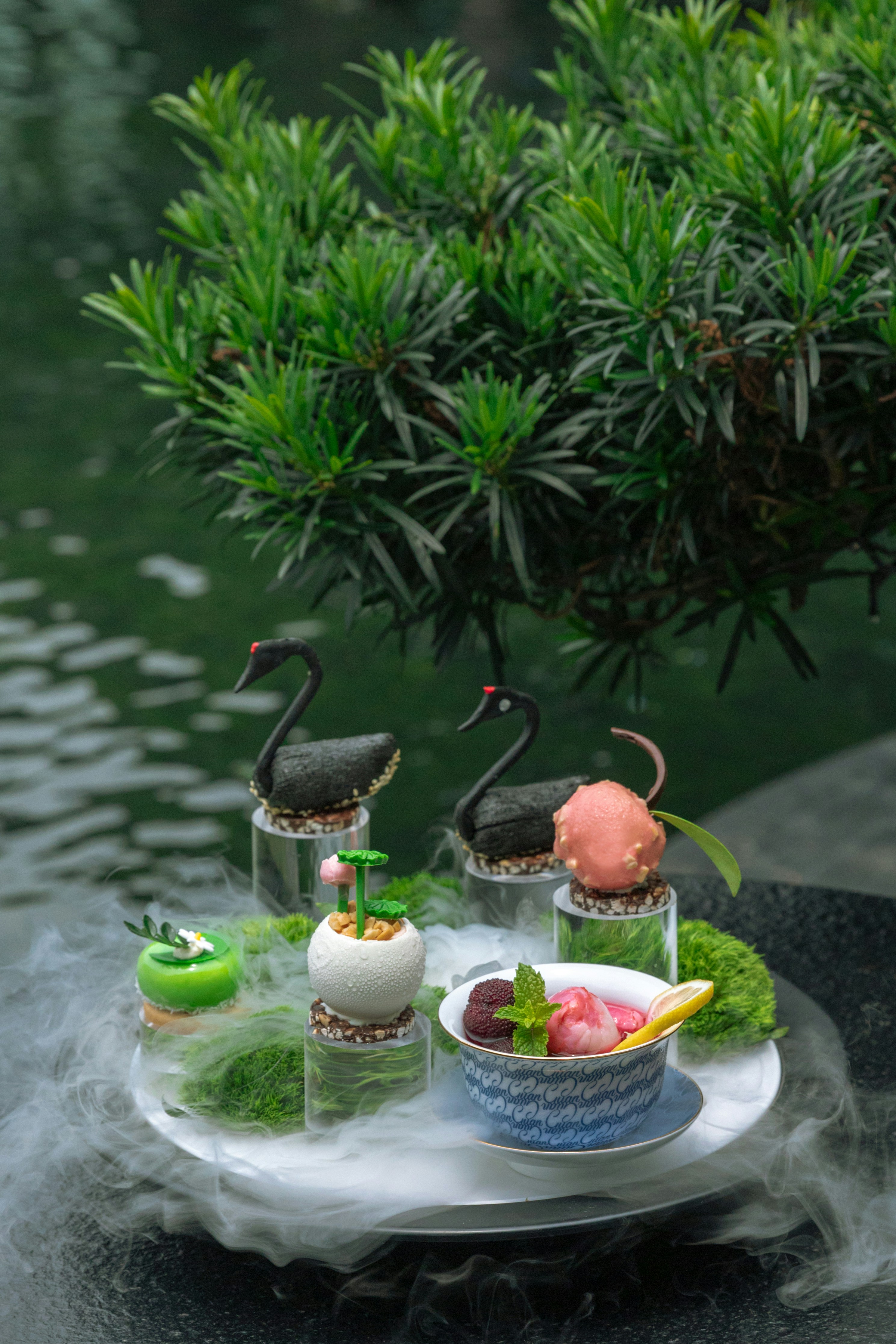 a plate of food on a table next to a pond