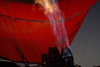 a red hot air balloon with smoke coming out of it