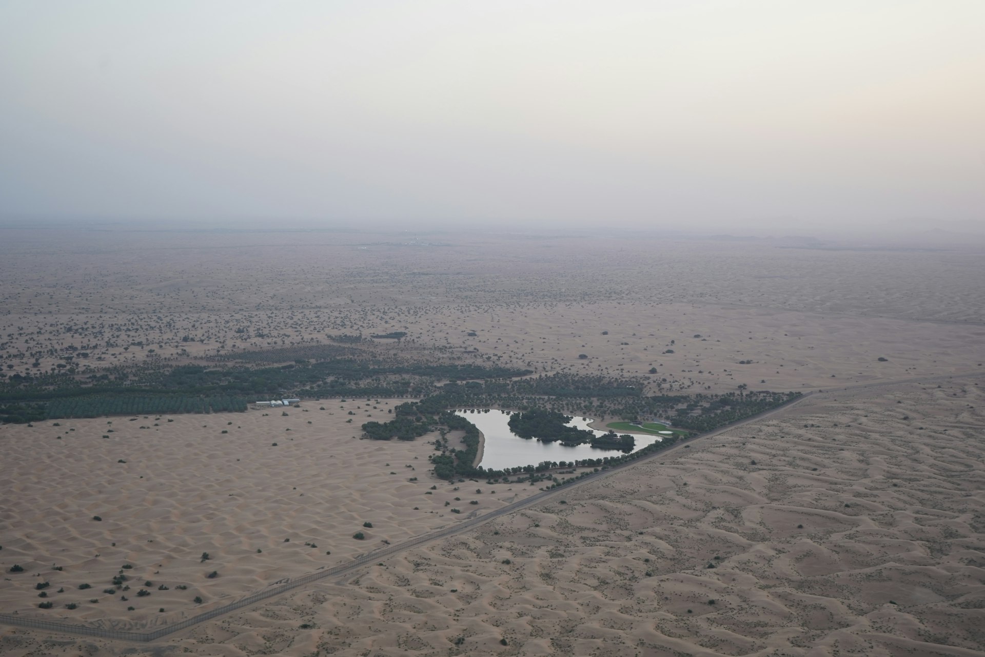 an aerial view of a lake in the middle of a desert