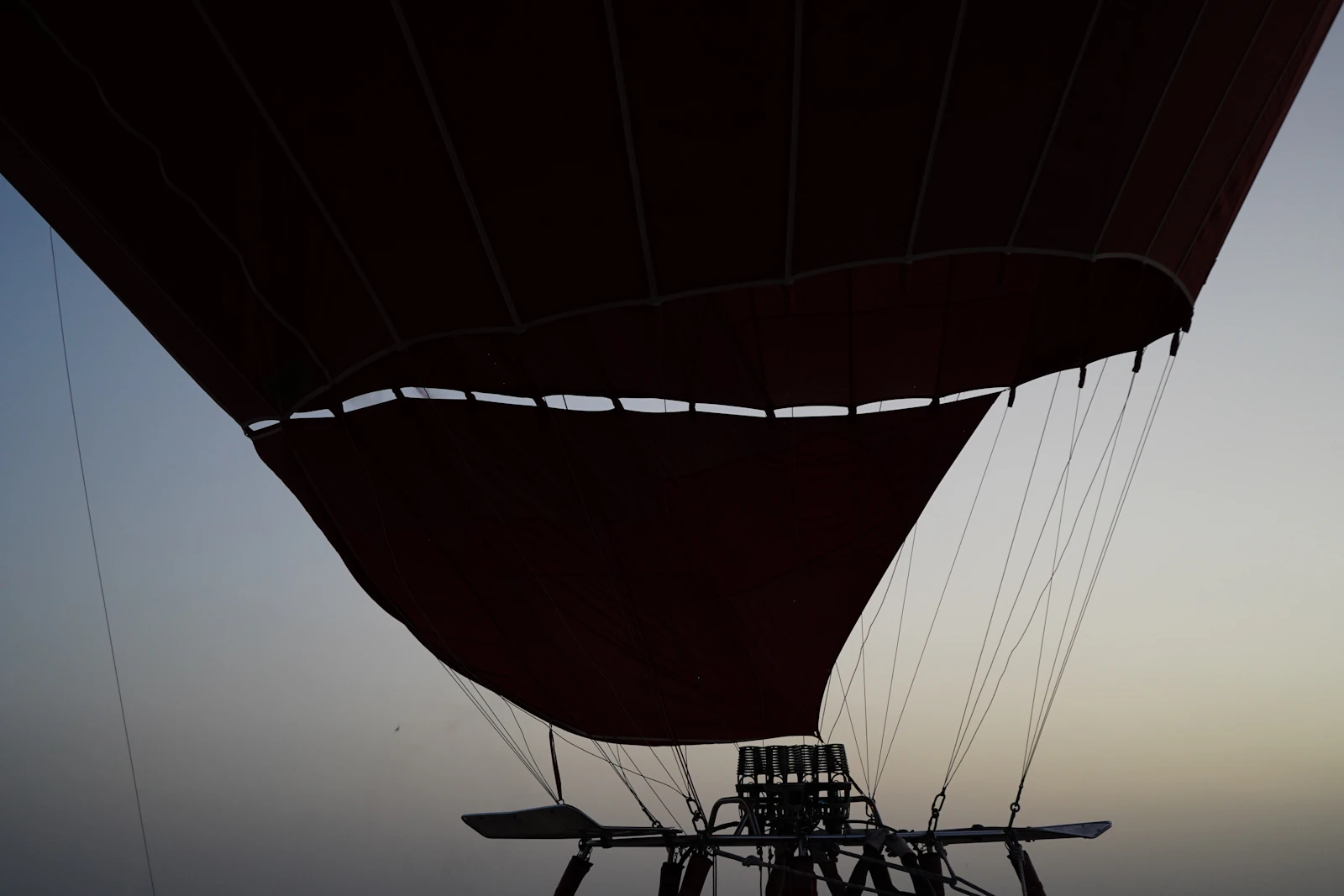 Hot air balloon envelope inflating against the dawn sky in the Dubai desert