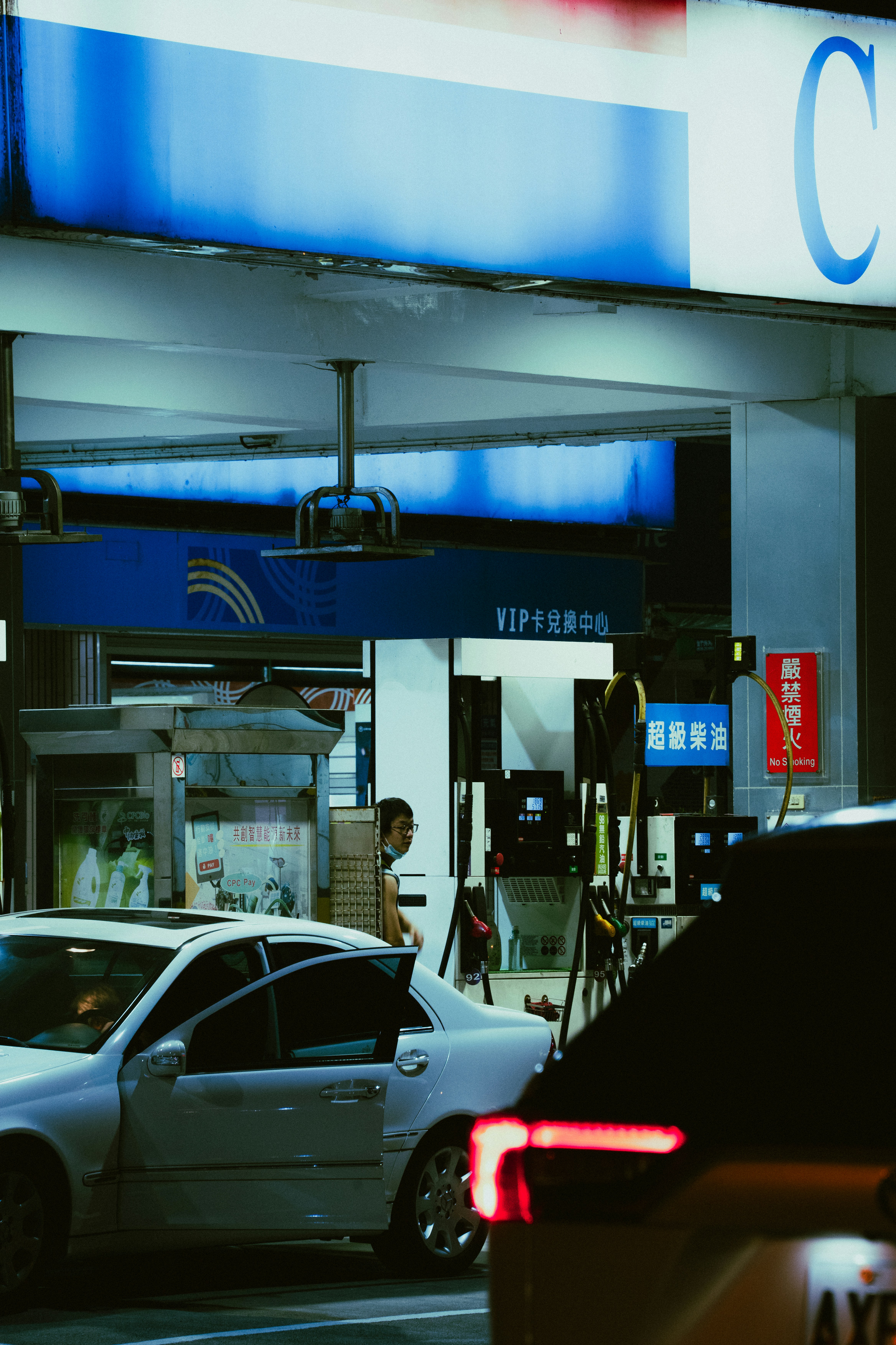 a gas station at night with cars parked in front of it
