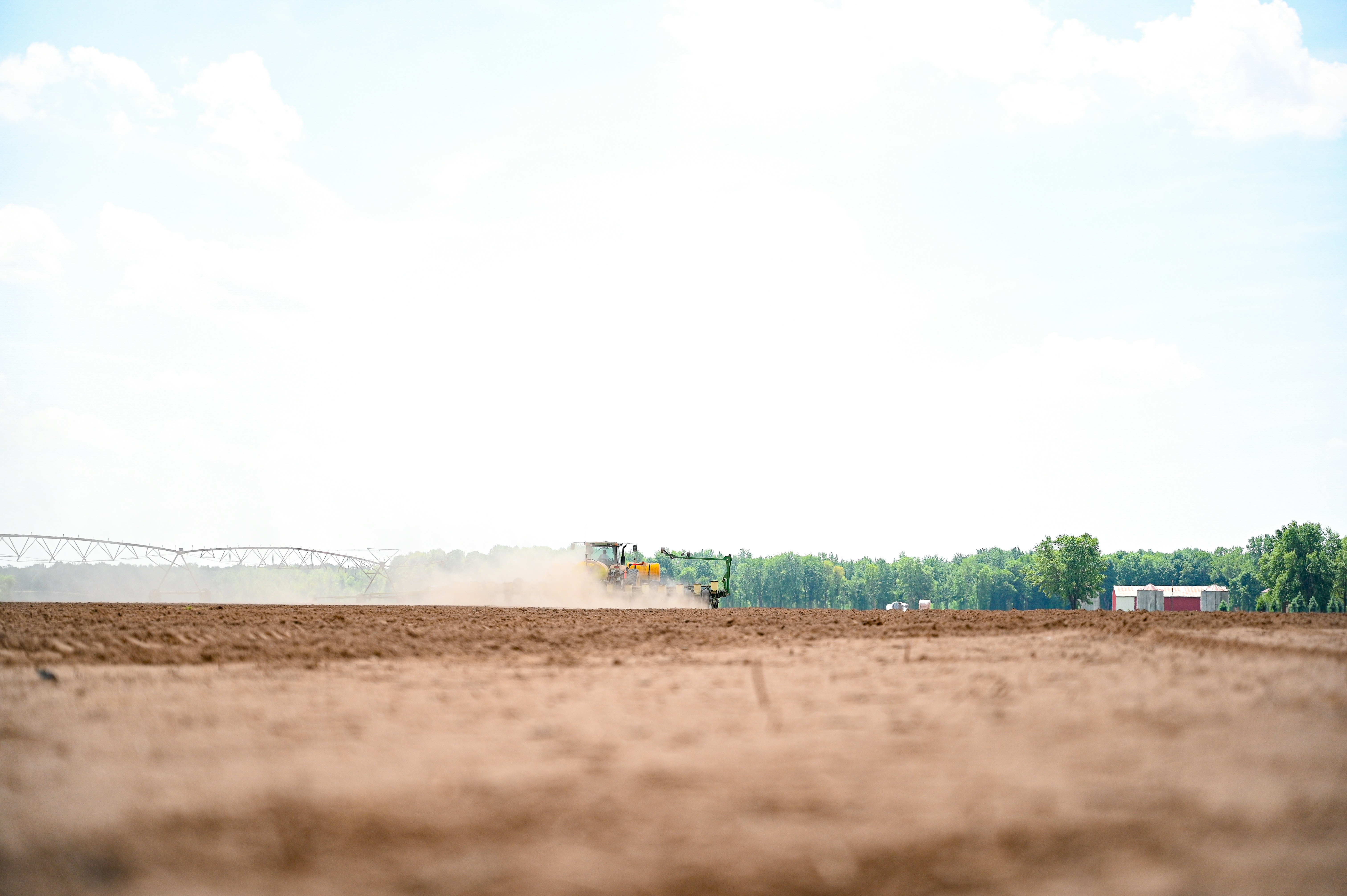 a tractor plowing a field with a duster