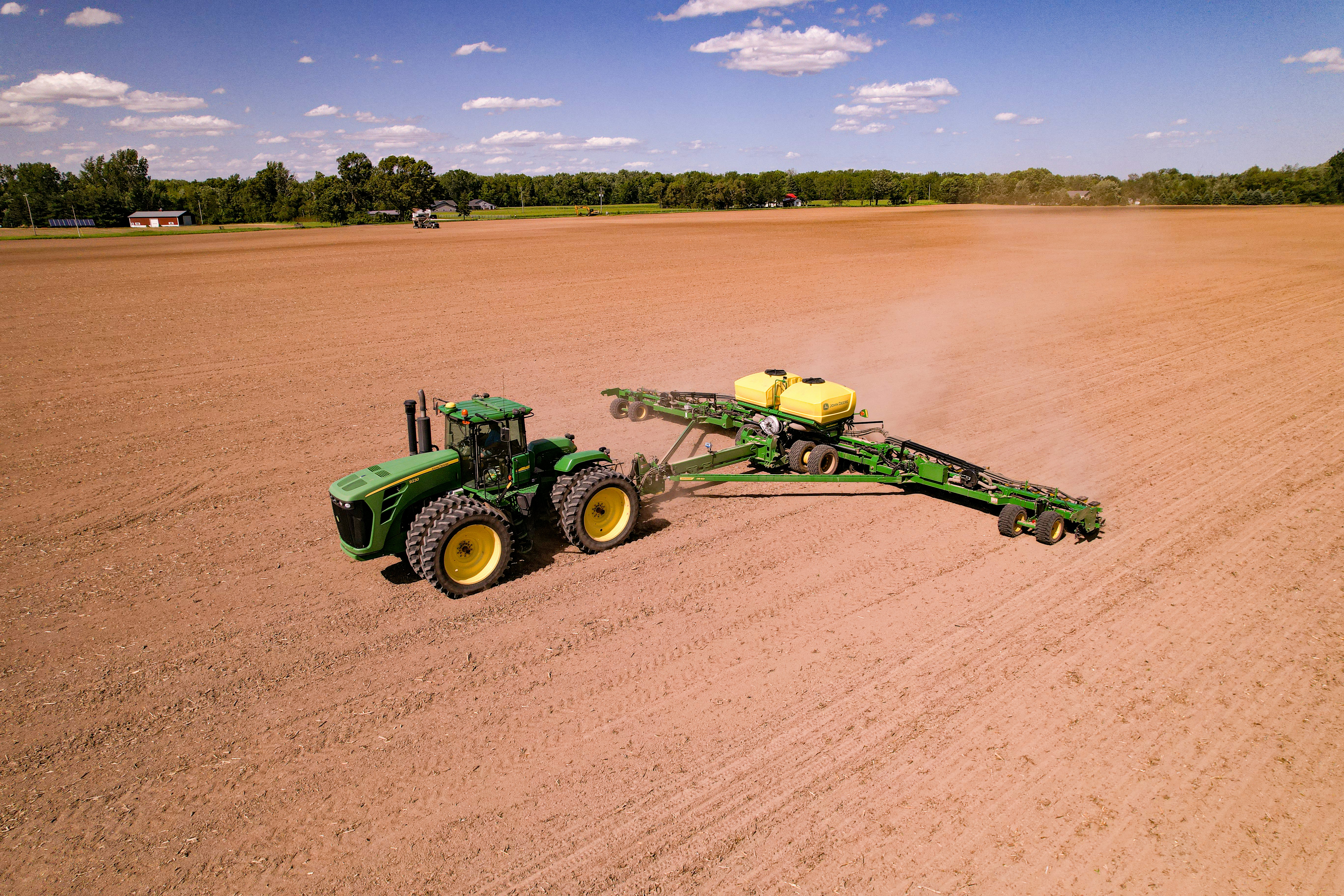 a tractor pulling a trailer behind it in a field