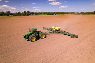 a tractor pulling a trailer behind it in a field
