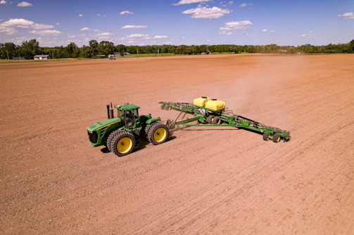 a tractor pulling a trailer behind it in a field