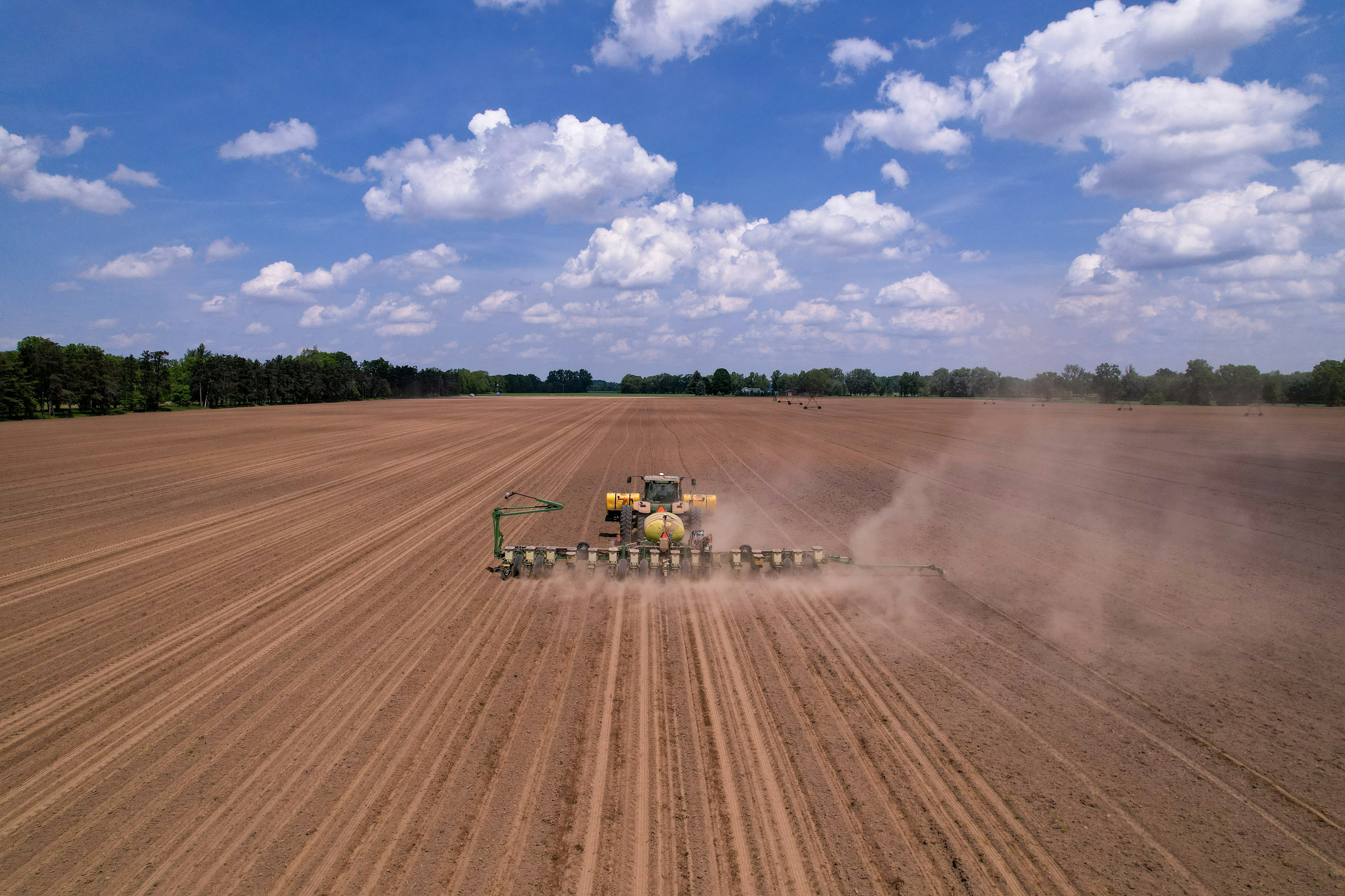 a tractor plowing a field with a sprayer