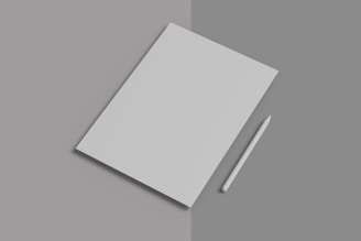 A white notebook with a pen on top of it