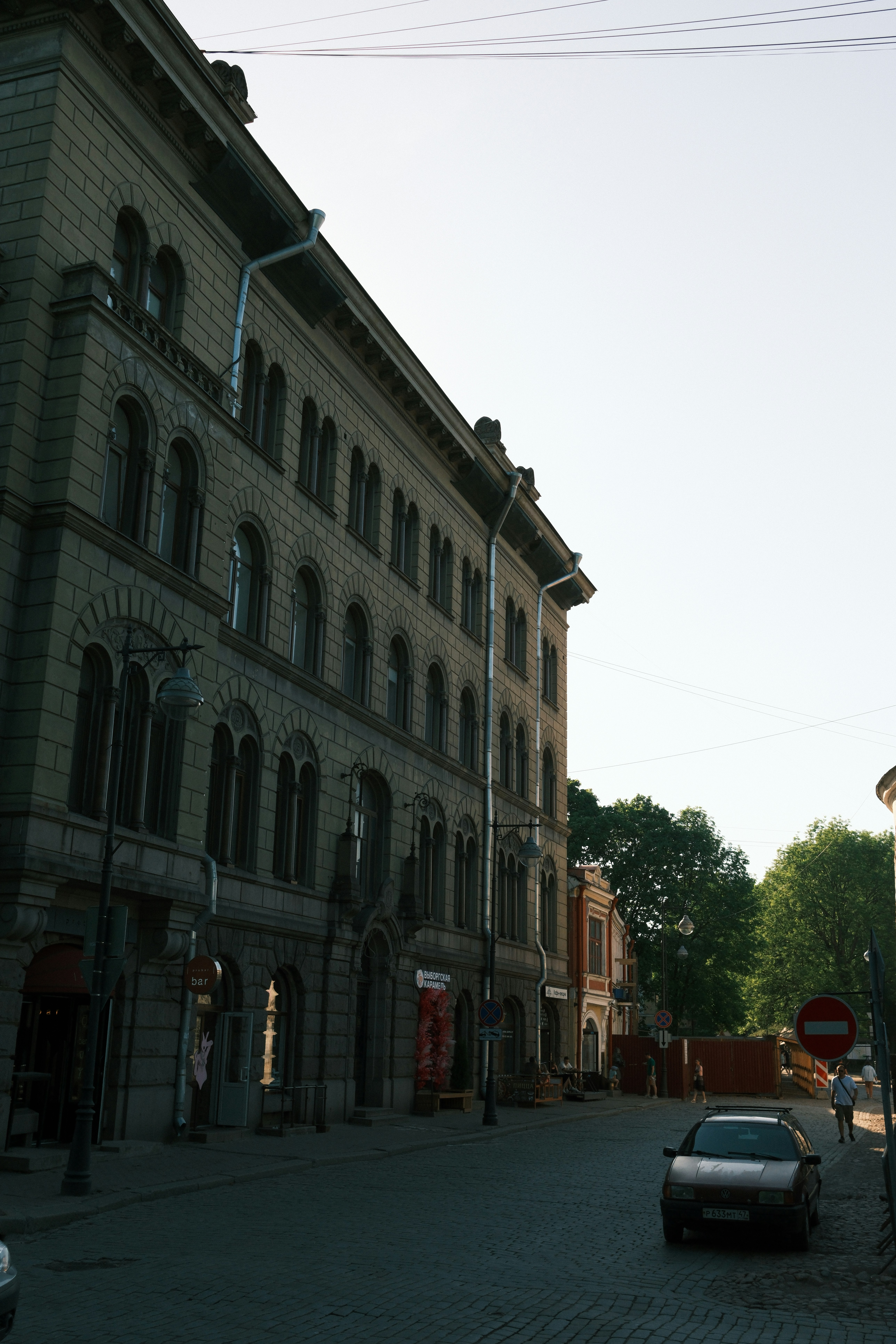a car parked on the side of a road next to a tall building