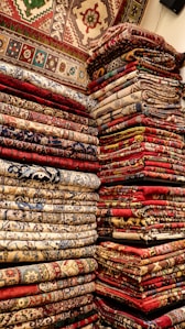 a large pile of colorful rugs in a room