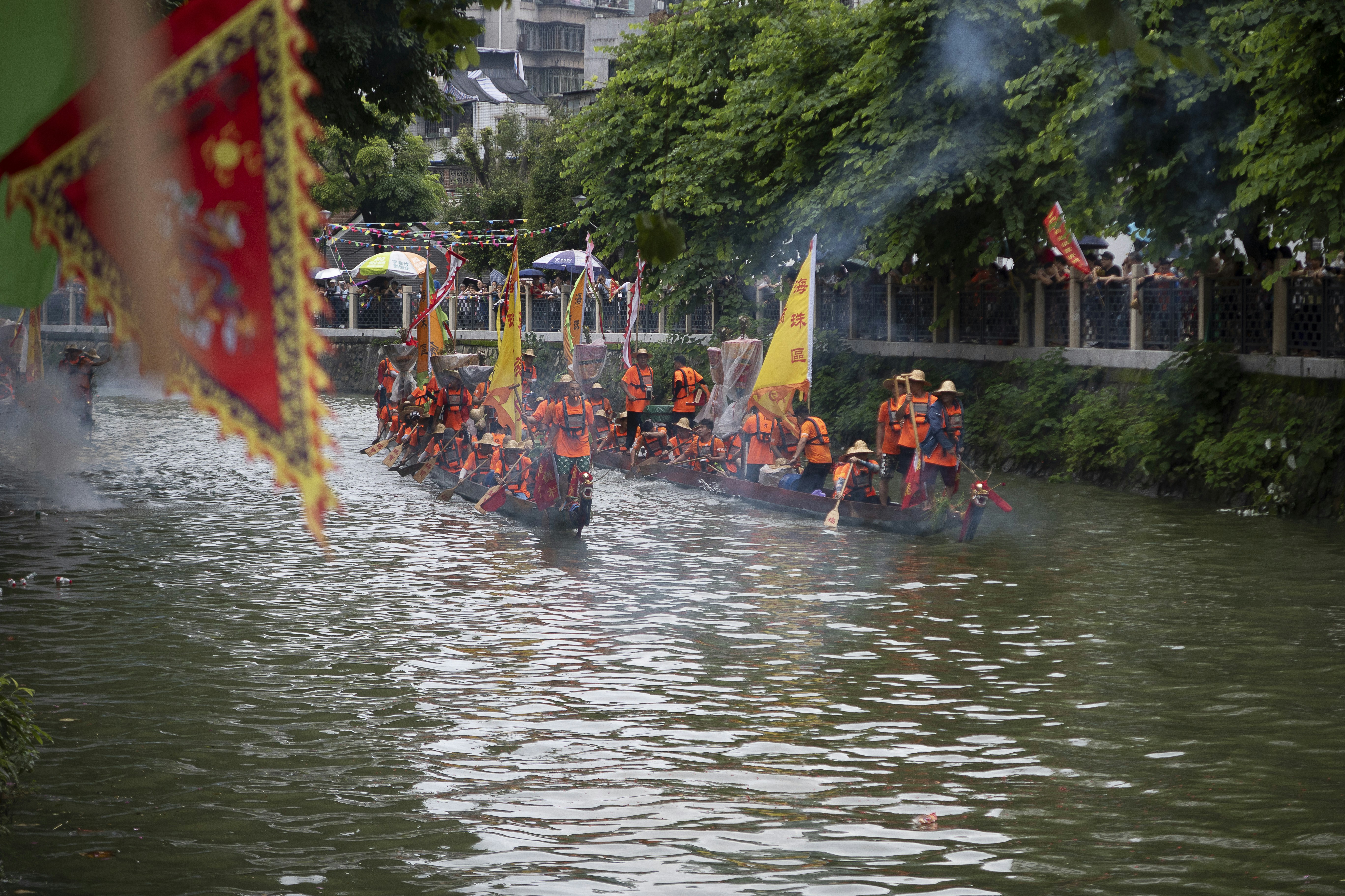 a group of people riding on top of boats down a river