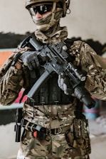 a man in camouflage holding a machine gun