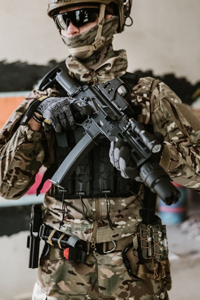 a man in camouflage holding a machine gun