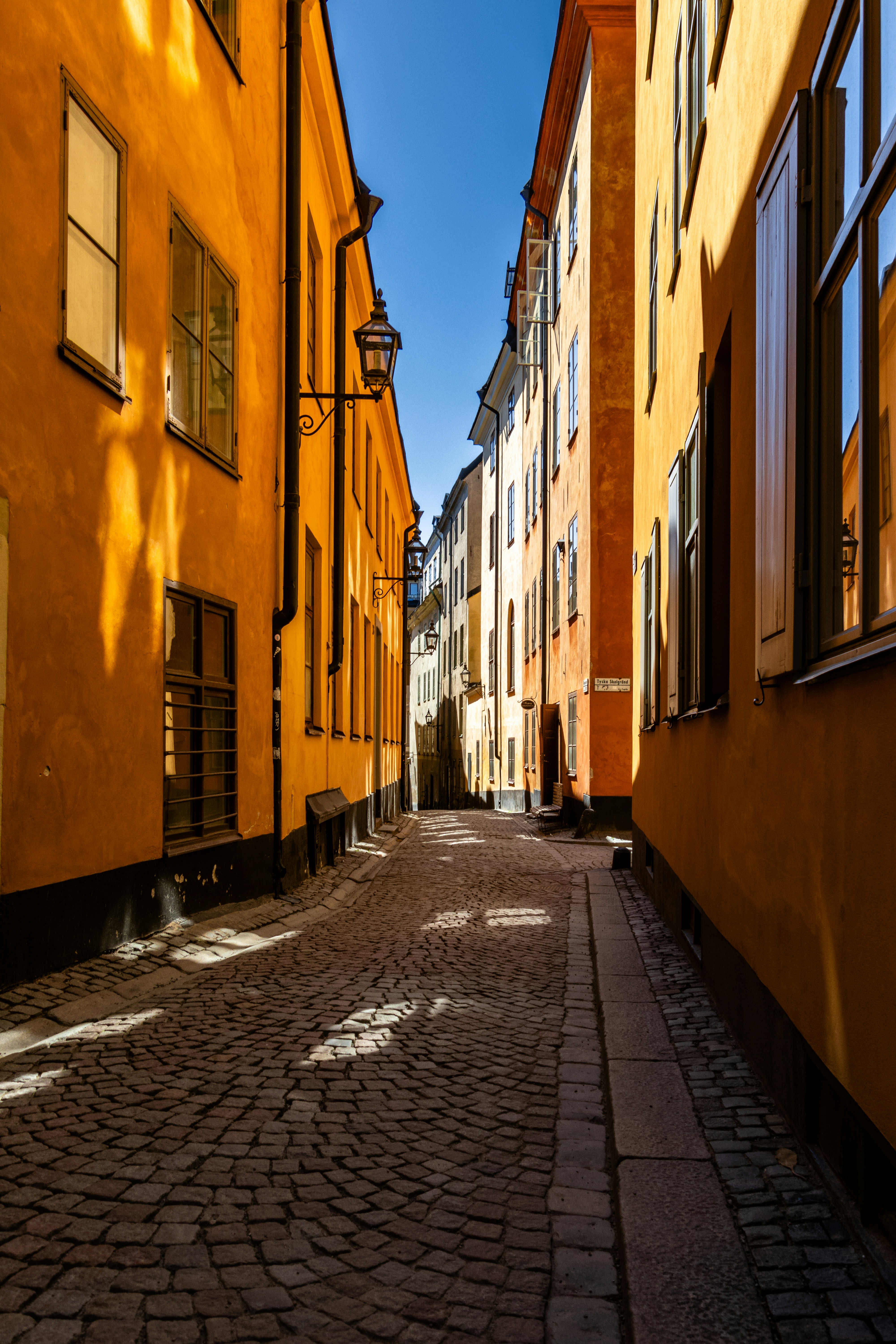 Eine Kopfsteinpflasterstraße, die von gelben Gebäuden gesäumt ist