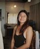 a woman in a black tank top standing in a room