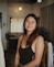 a woman in a black tank top standing in a room