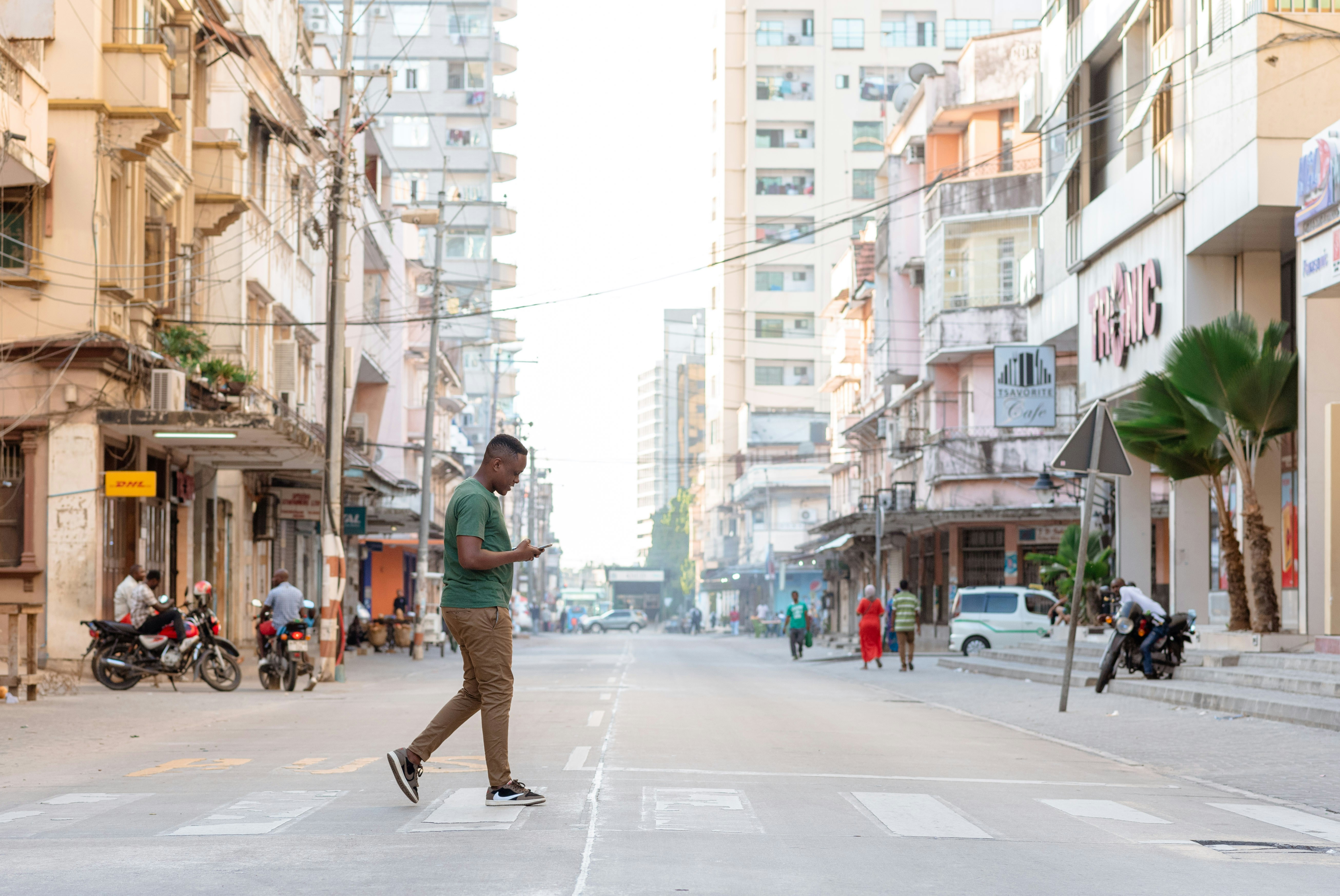 a man walking down a street while using a cell phone