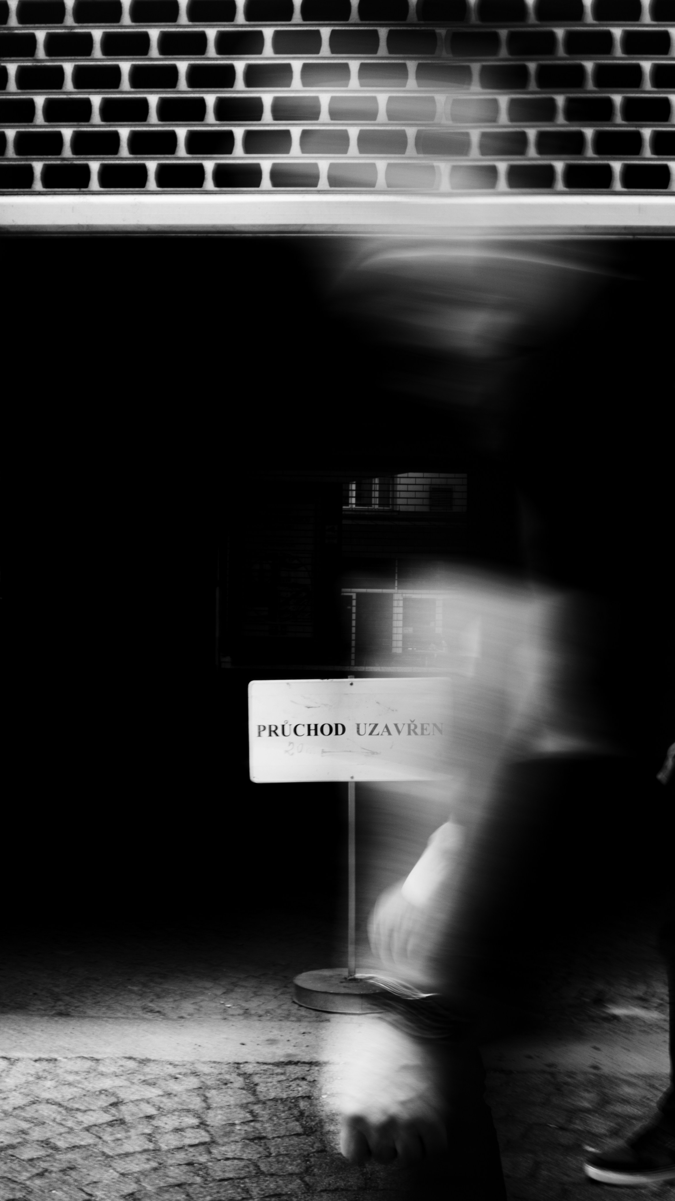 a blurry photo of a person walking past a sign