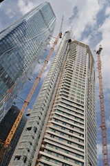 a very tall building with some cranes around it