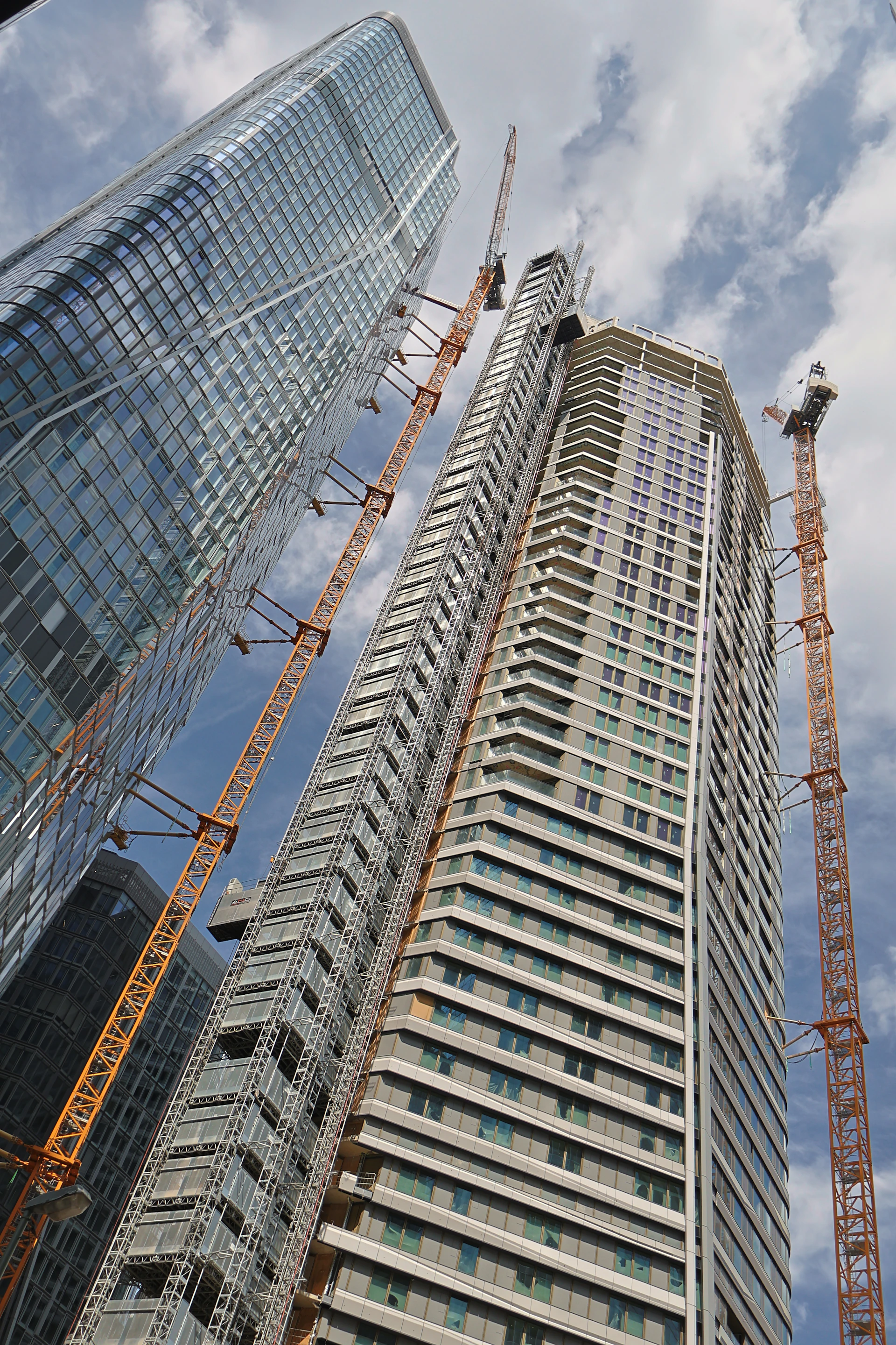 a very tall building with some cranes around it