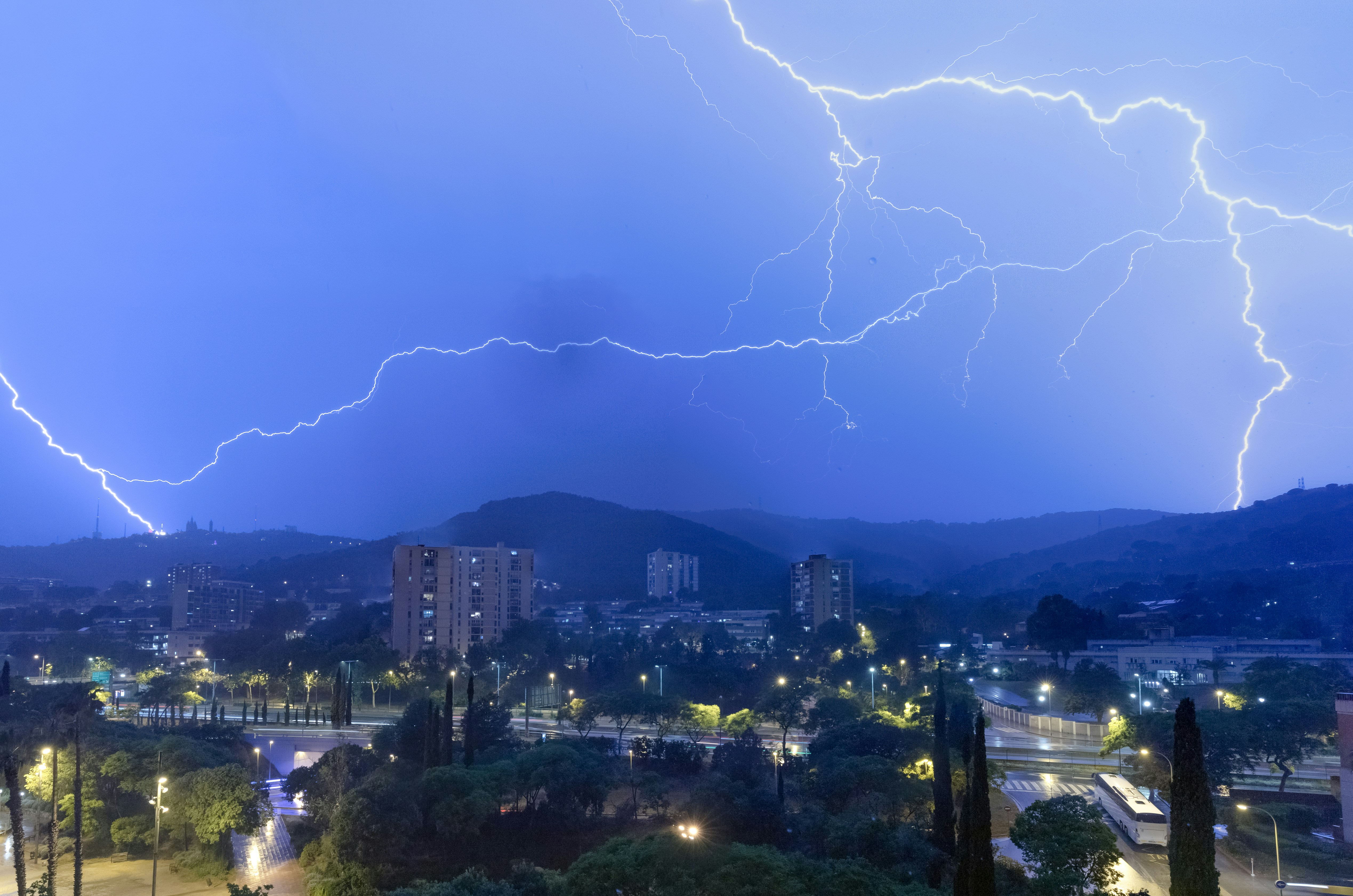 una tormenta eléctrica sobre una ciudad por la noche