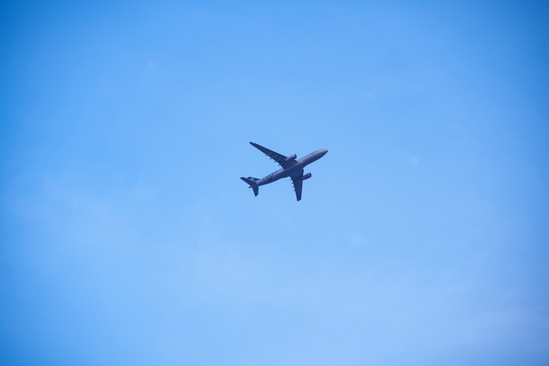 a large jetliner flying through a blue sky,