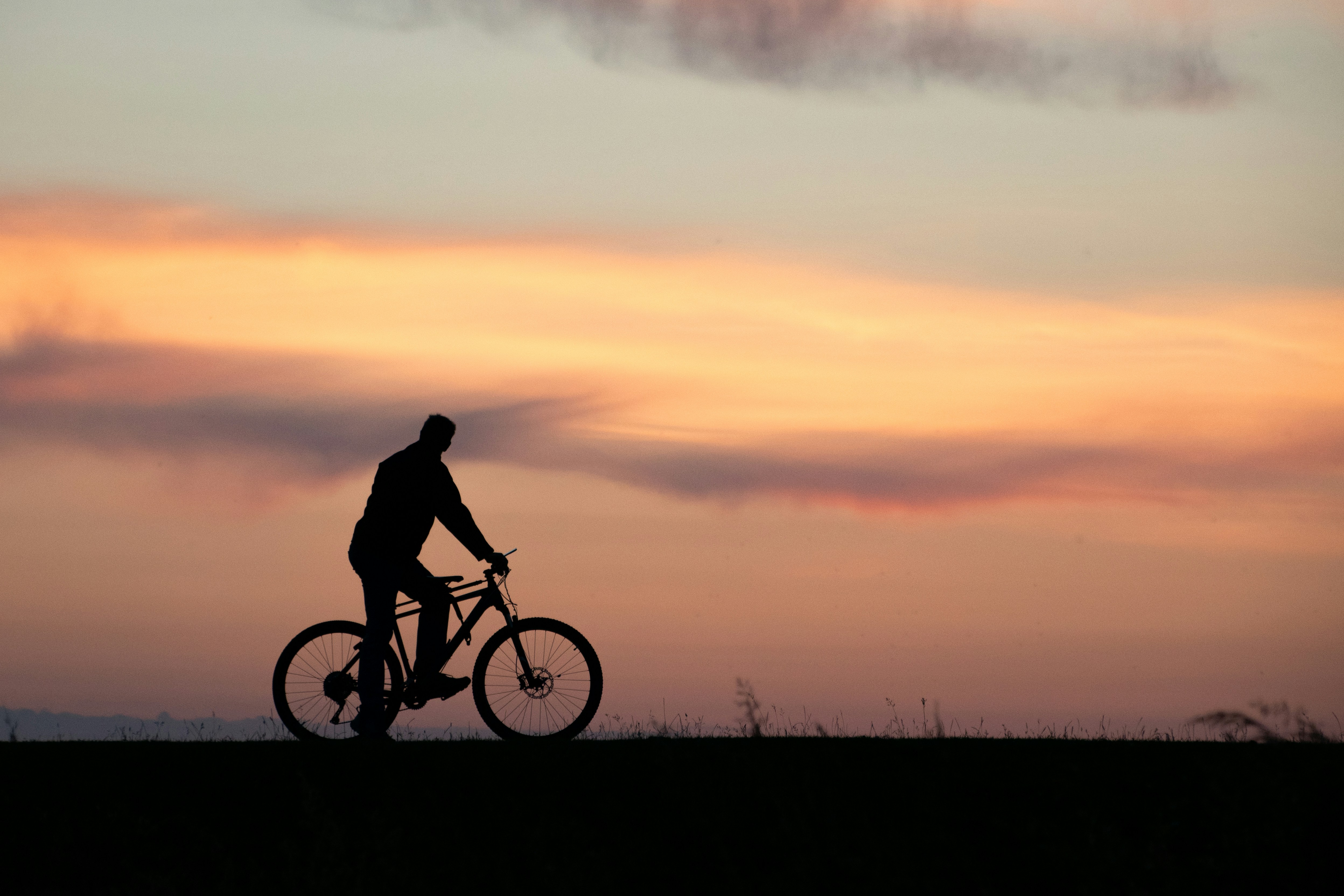 a man riding a bike on top of a grass covered field