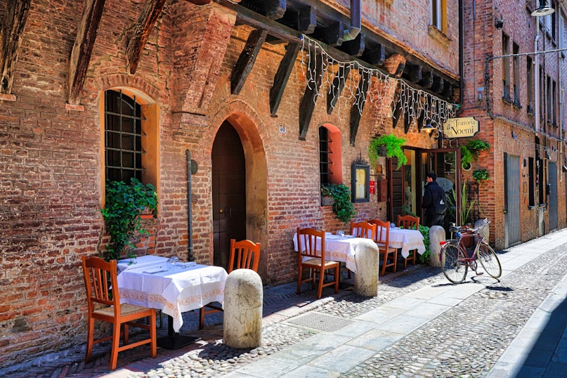 a cobblestone street lined with tables and chairs