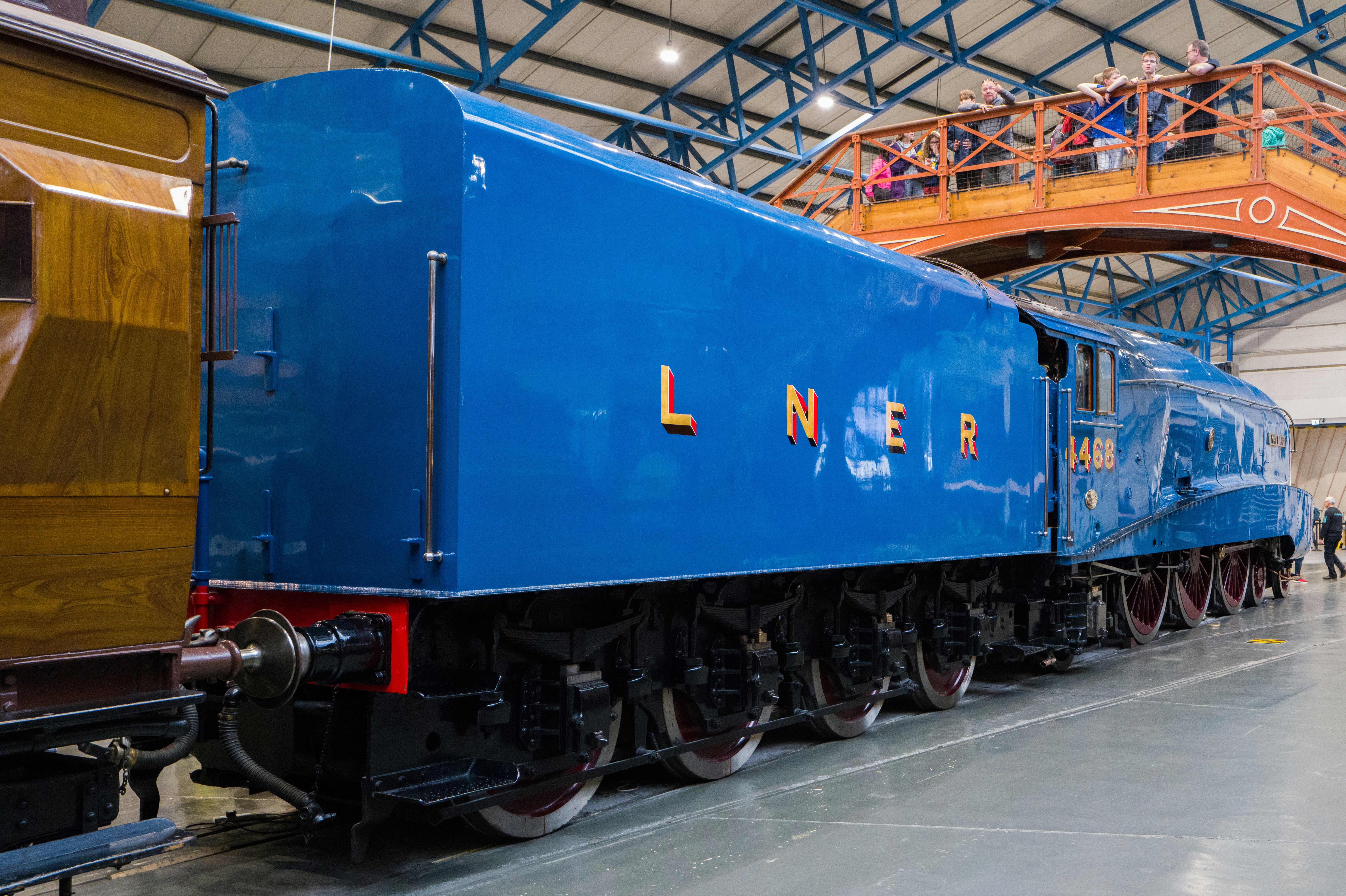a blue train sitting inside of a train station