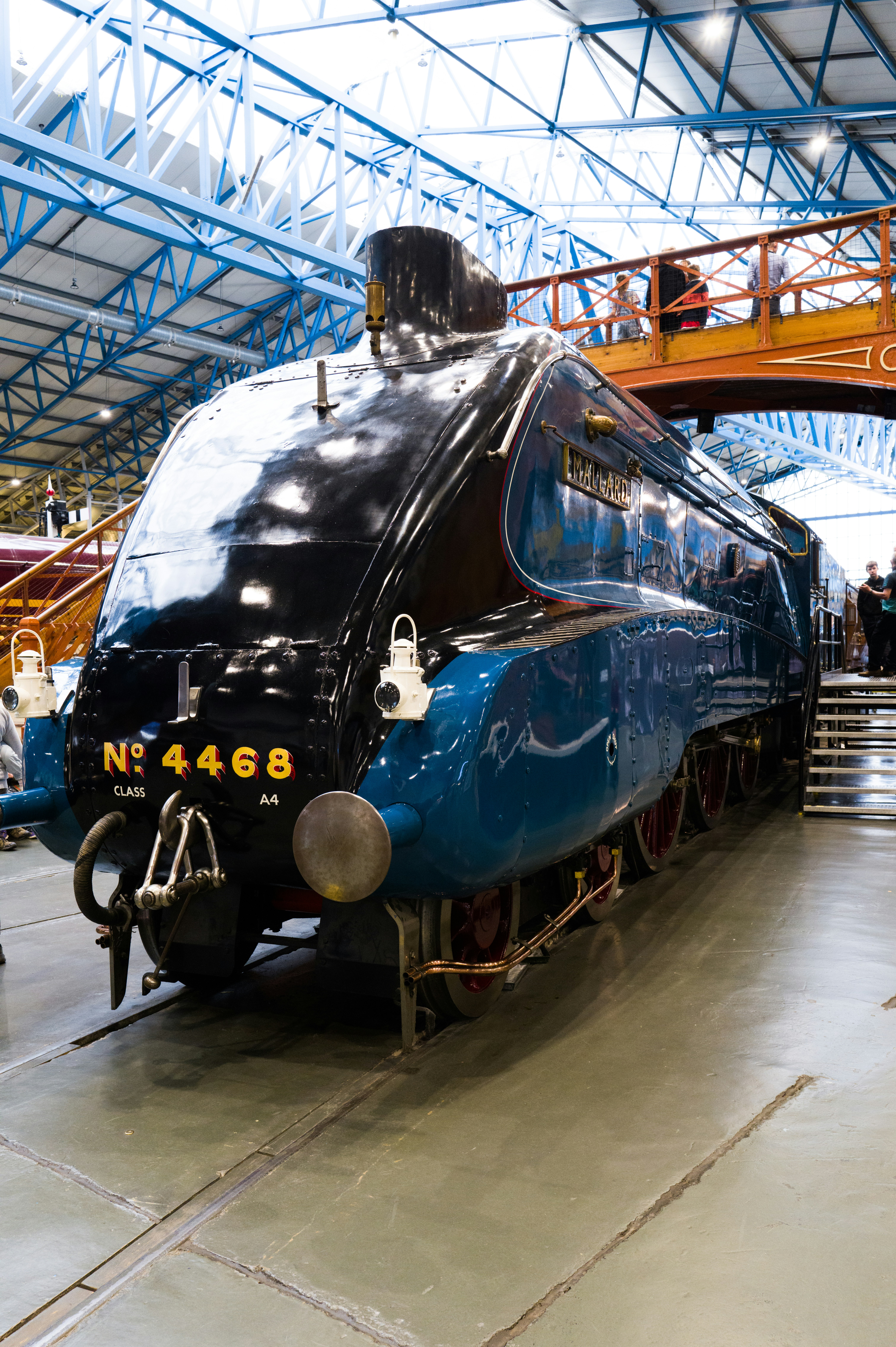 a blue and black train sitting inside of a train station