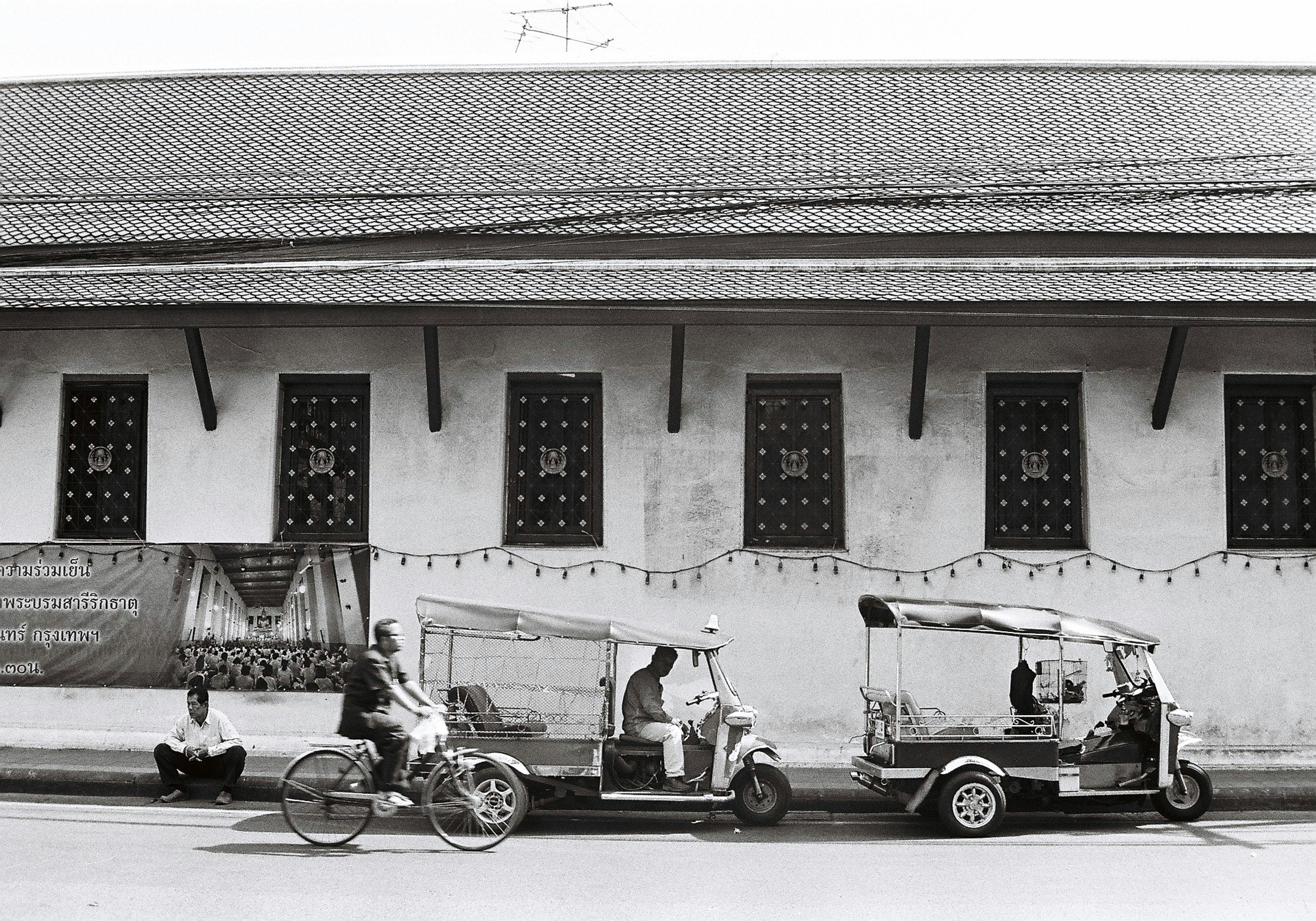 a black and white photo of three vehicles parked in front of a building