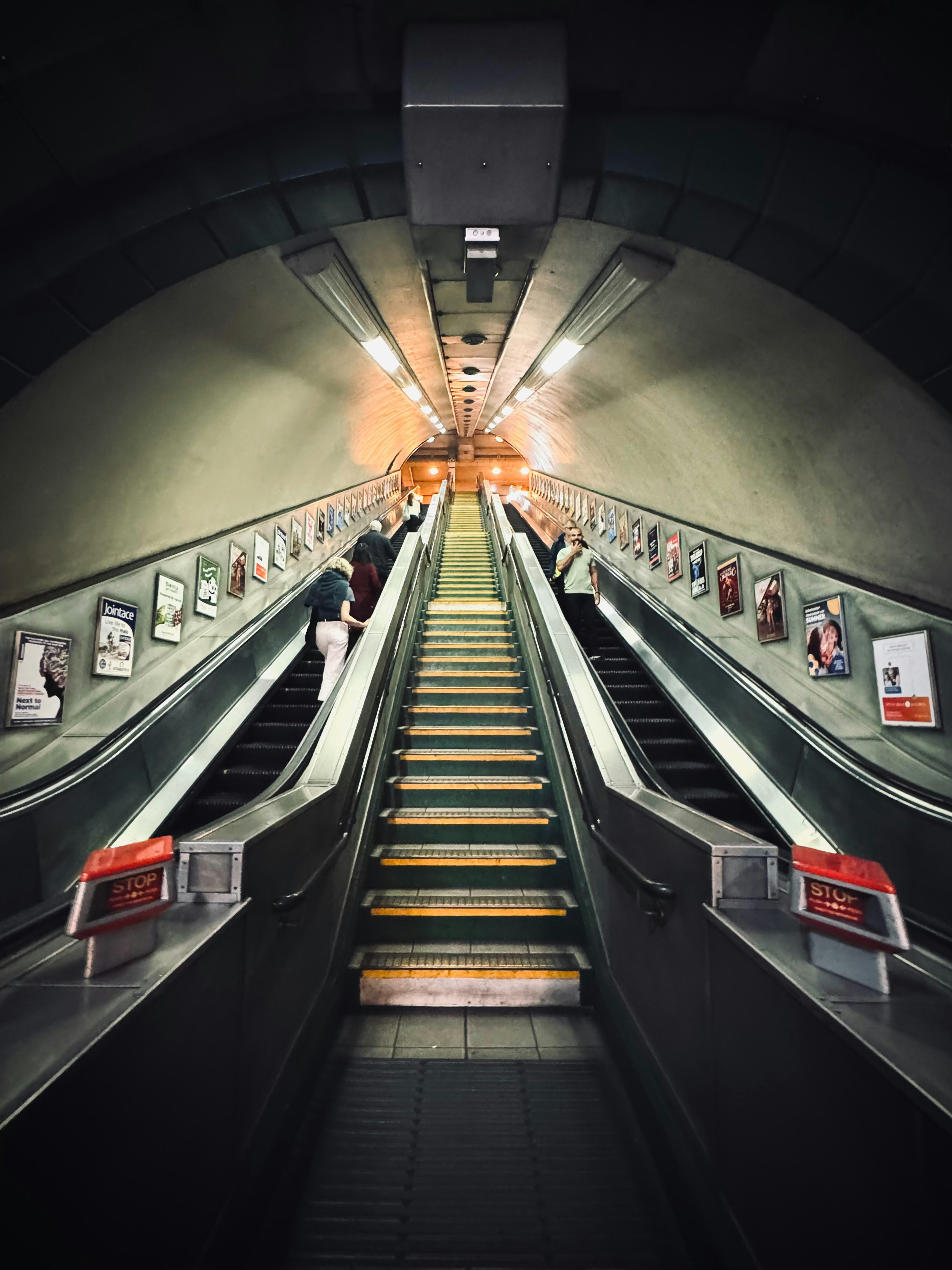 an escalator with a bunch of people riding down it