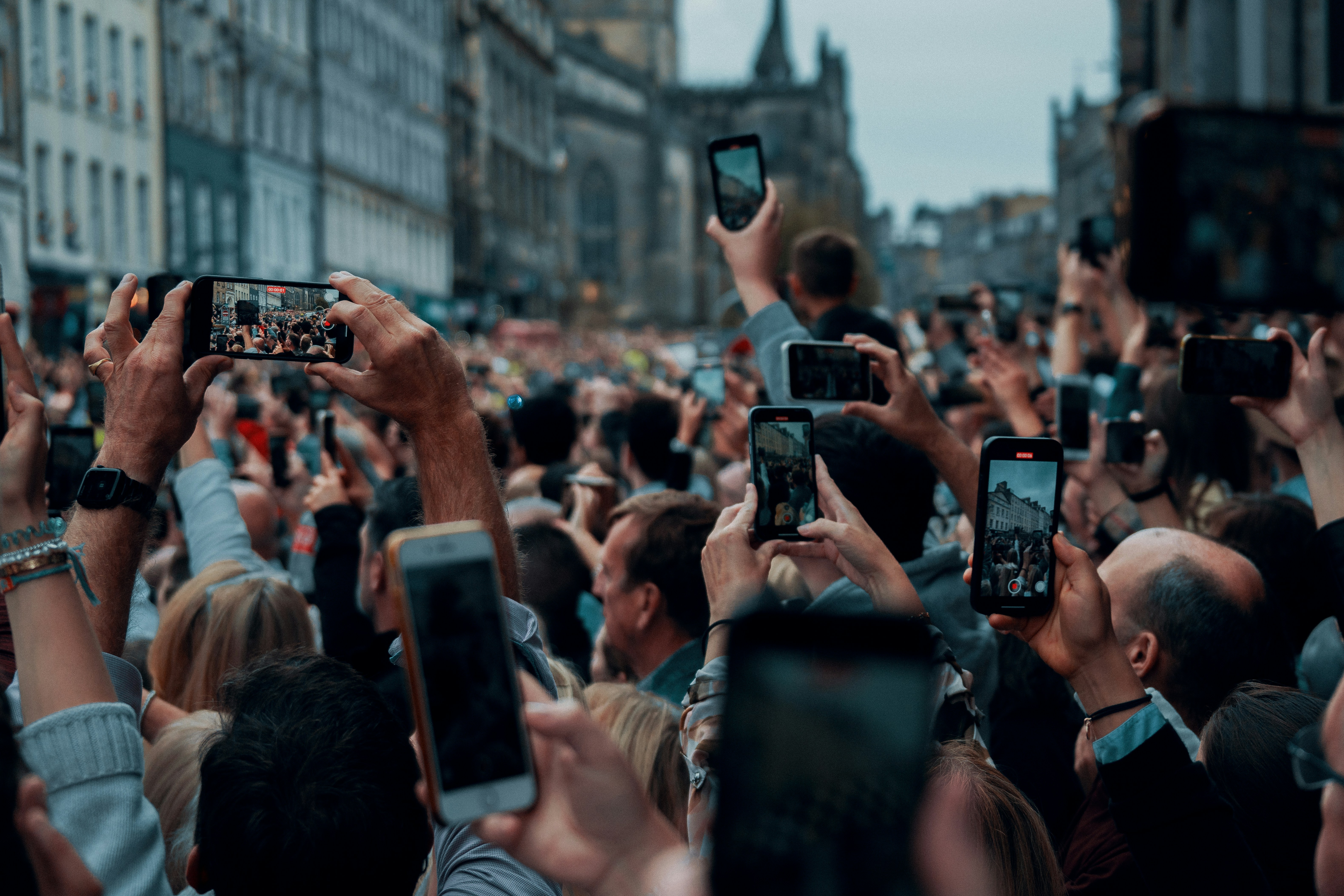 Lindsay Lohan surrounded by a crowd of fans holding up phones, symbolizing her magnetic manifestation comeback.