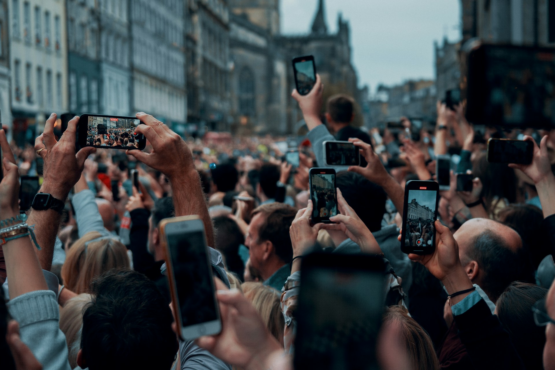 a crowd of people taking pictures with their cell phones