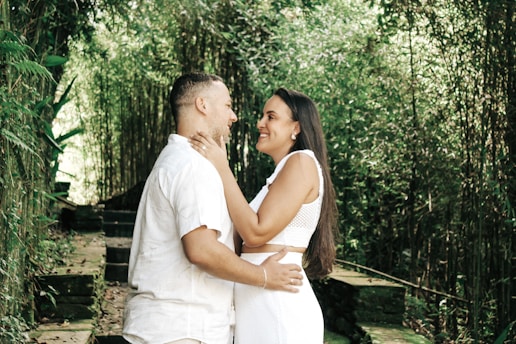 a man and a woman standing in front of bamboo trees