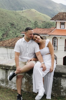 a man and a woman are sitting on a wall