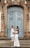a man and woman standing in front of a blue door